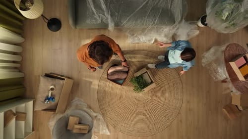 Top View of Apartment Living Room Man and Woman Coming in Room Checking Stuff Sitting on the Sofa