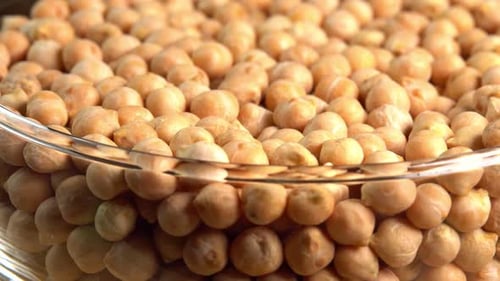 Dry chickpeas or dried garbanzo beans rotating in a glass bowl side view. Ingredient for falafel