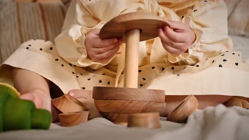 Child Plays with Wooden Stacking Rings Toy