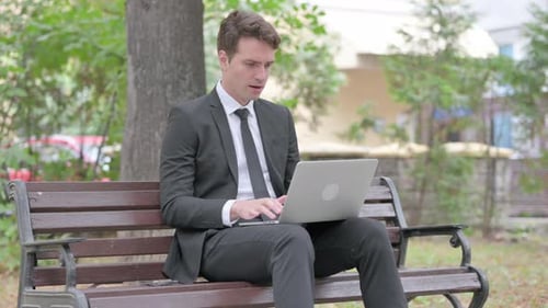Man in Suit Celebrating Good News on Laptop