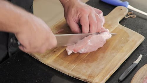 Chef Cutting Raw Meat on Wooden Cutting Board