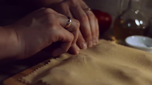 Closeup of Woman's Hands Sticking the Sheets of Dough with Meat Filling Inside