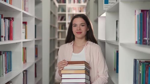 Woman with High Book Stack in Library
