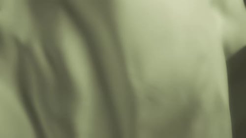 Silky pastel green fabric waving in the wind