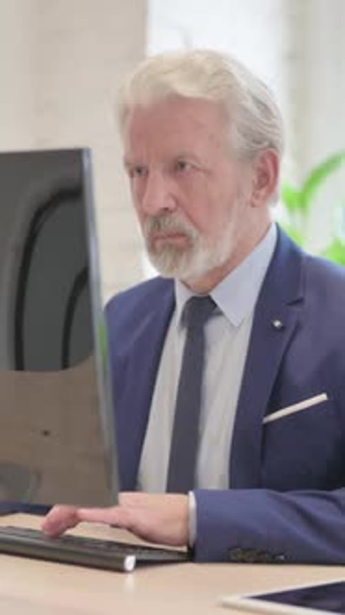 Senior Man Working at Computer in Office