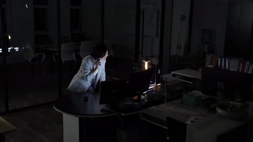 Woman Talking on Phone at Night in Office