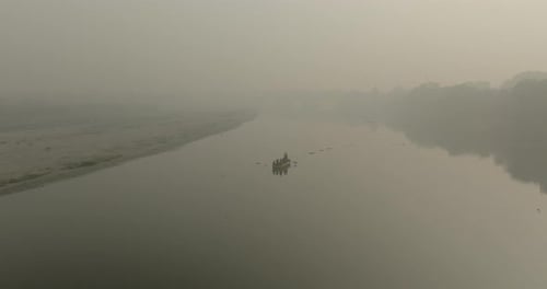 Vista aérea del sereno Yamuna Ghat con barcos, India.