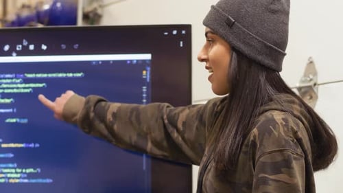 Woman Explains Code on Screen Using a Tablet