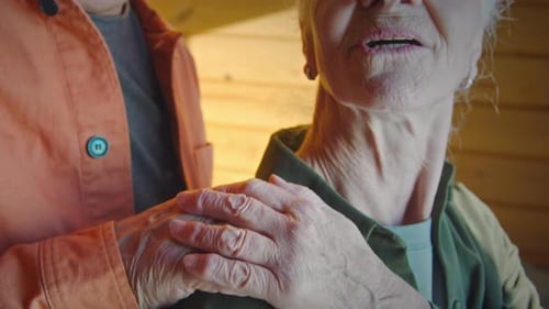 Elderly Husband and Wife Embracing and Chatting by Window