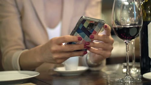 Mujer navegando por Internet en un teléfono inteligente en un café