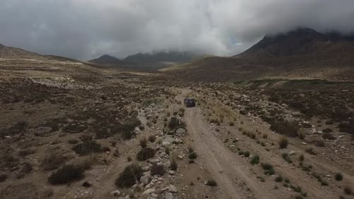 Drone: flies behind a car through a gorge in the mountains of Kyrgyzstan