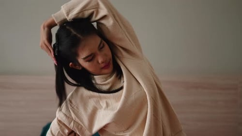 Attractive woman stretches to warm up indoors
