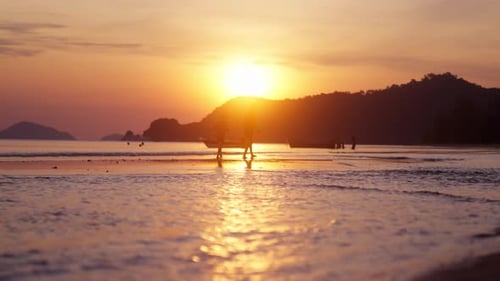 Boys Strolling In The Distance At A Beach