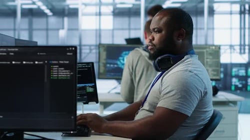Man Coding at Computer in Modern Office
