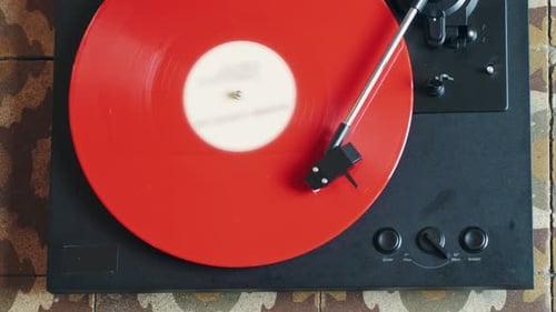Spinning Red Vinyl Record on a Black Turntable