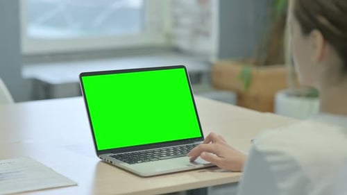 Young Woman Working on Laptop with Green Chroma Screen