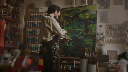 Middle-Aged Artist Creating Colourful Abstract Painting in Hazy Workshop