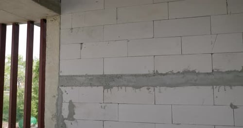Panning from the left to the right, showing some hollow blocks stacked up together for a wall in a b