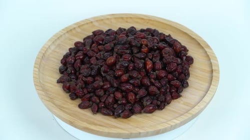 Close view rose hips. Dried Rose Hips. Dog rose rotating on the tray in white background.