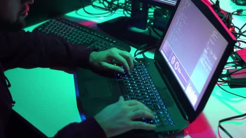 People Typing at Computers in Dark Tech Room
