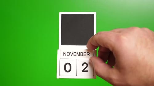 Hand Changing Date Calendar to November 2nd