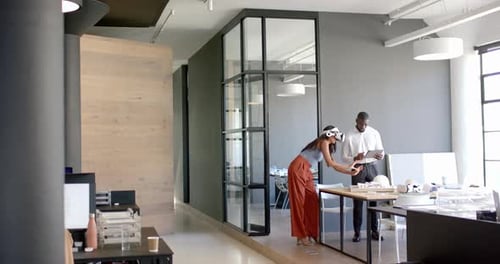 Business diverse colleagues discussing work, using tablet and documents in modern office