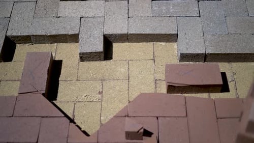 Construction zone detail of brick paver custom emblem in herringbone pattern.