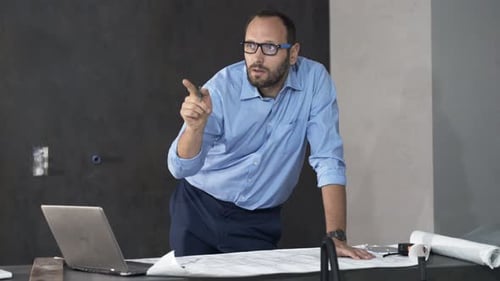 Architect Working on Blueprints in Modern Office
