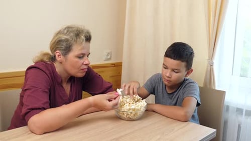 Woman and Child Eating Popcorn Together