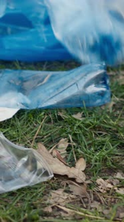 Garbage Being Collected and Placed in Recycling Bag