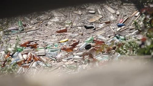Schwimmende Plastikflaschen und verschiedener Müll in verschmutztem Wasser