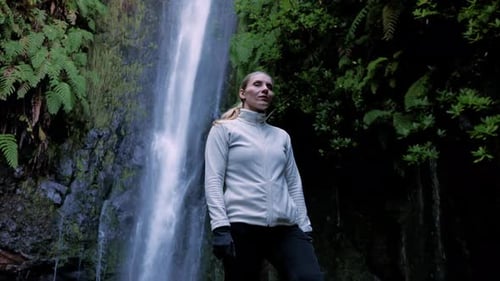 Silent Journeyer Admiring Peaceful Stream Amidst Green Surroundings