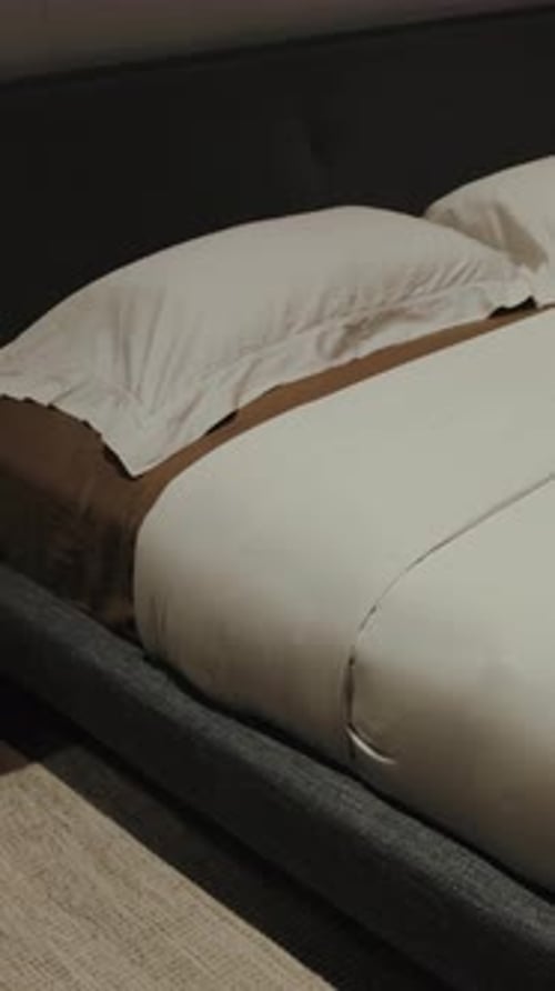 Person Resting Head on Pillow in Bed