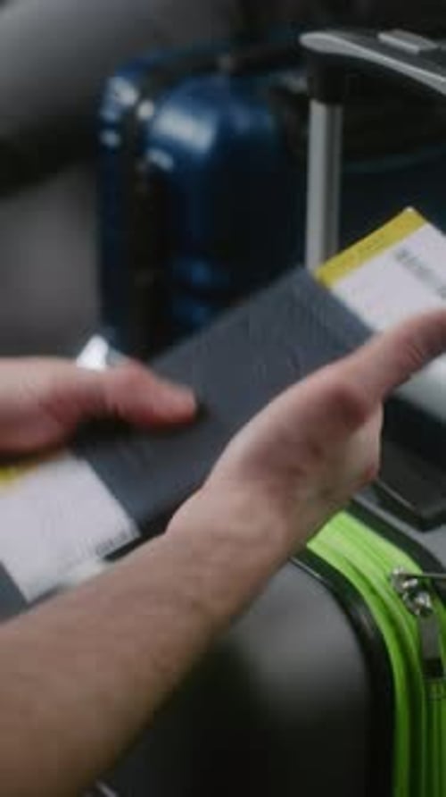 Close Up of Man with Suitcase Sitting in Departure Lounge of Airline Hub Waiting for Flight