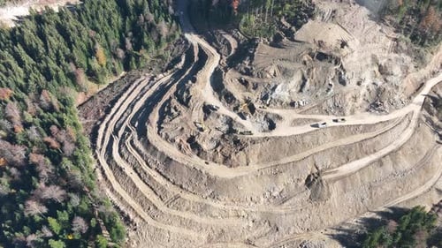 Industrial Mine Excavators are Digging the Soil in the Construction Site and Loading Trucks