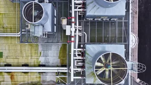 Top down view of industrial HVAC cooling towers on the building roof