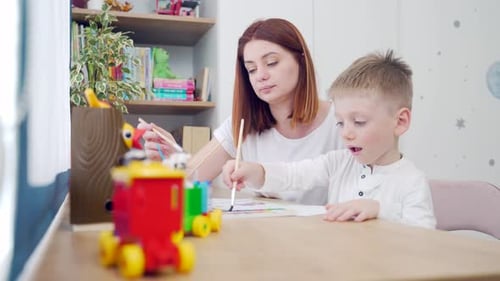 Woman and Child Painting Together Indoors