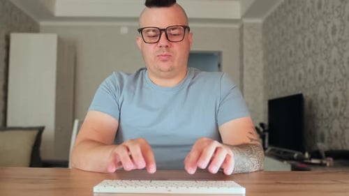 Man With Mohawk Typing on a Keyboard Indoors