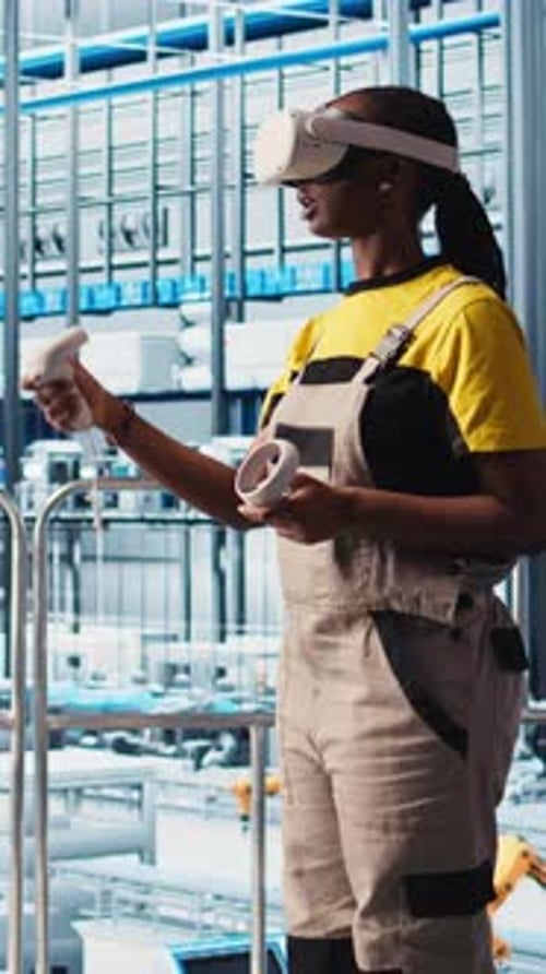 Vertical Video Engineer Wearing VR Headset in Smart Factory Looking at Data to Do Optimizations