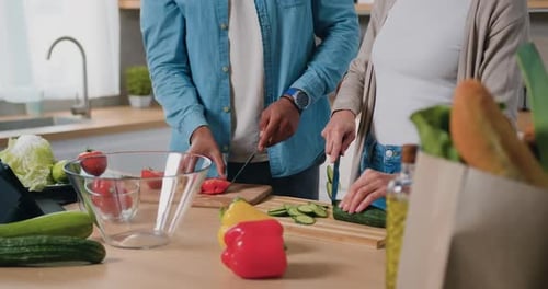Couple Cutting Vegetables in Kitchen Together