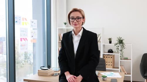 Confident Businesswoman Standing at Desk in Modern Office Workspace