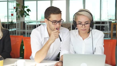 Office Workers Discussing and Collaborating Over Laptop