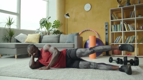 A Man Performs Leg Exercises in His Cozy Living Room Showing Commitment