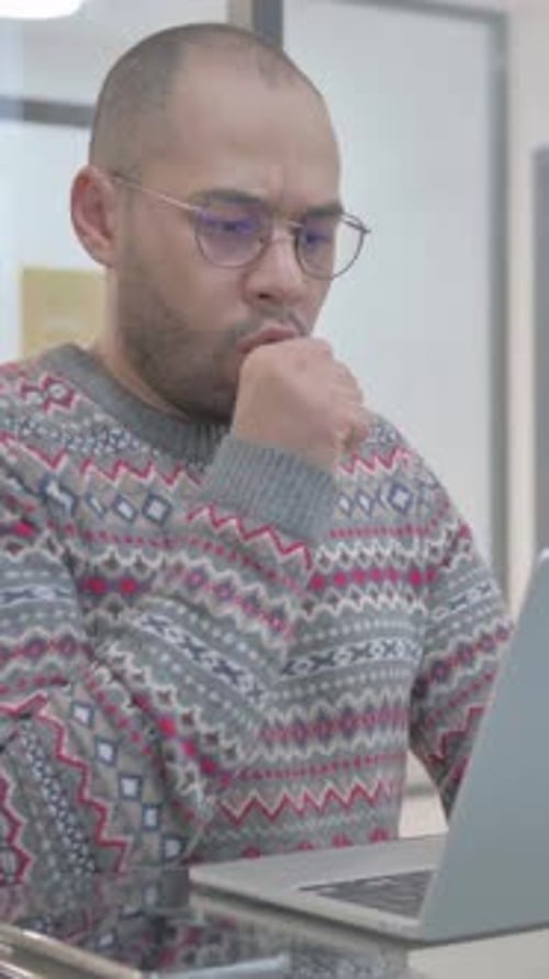 Man Works on Laptop Computer in Office