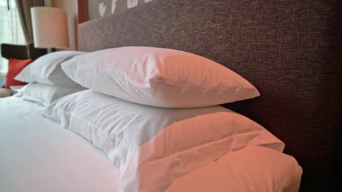 Hotel Room Bed with White Sheets and Pillows