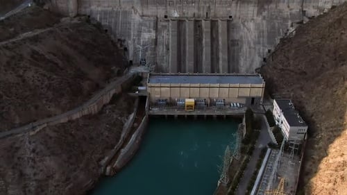Aerial view of hydroelectric power station surrounded with mountains