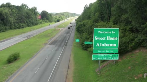 Welcome to Sweet Home Alabama sign along highway. Home of World Games. Dekalb County. Aerial drone v