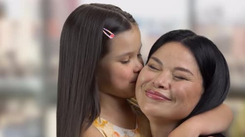 Girl Kisses Woman Affectionately in a Close Shot