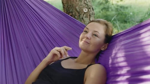 Woman Relaxing in Hammock on Summer Day