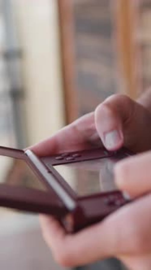 Hands Play Video Game on Handheld Console